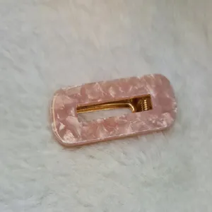 Hovedbilde H&aring;rspenne i gullfarget metall og marmorert hard plast 